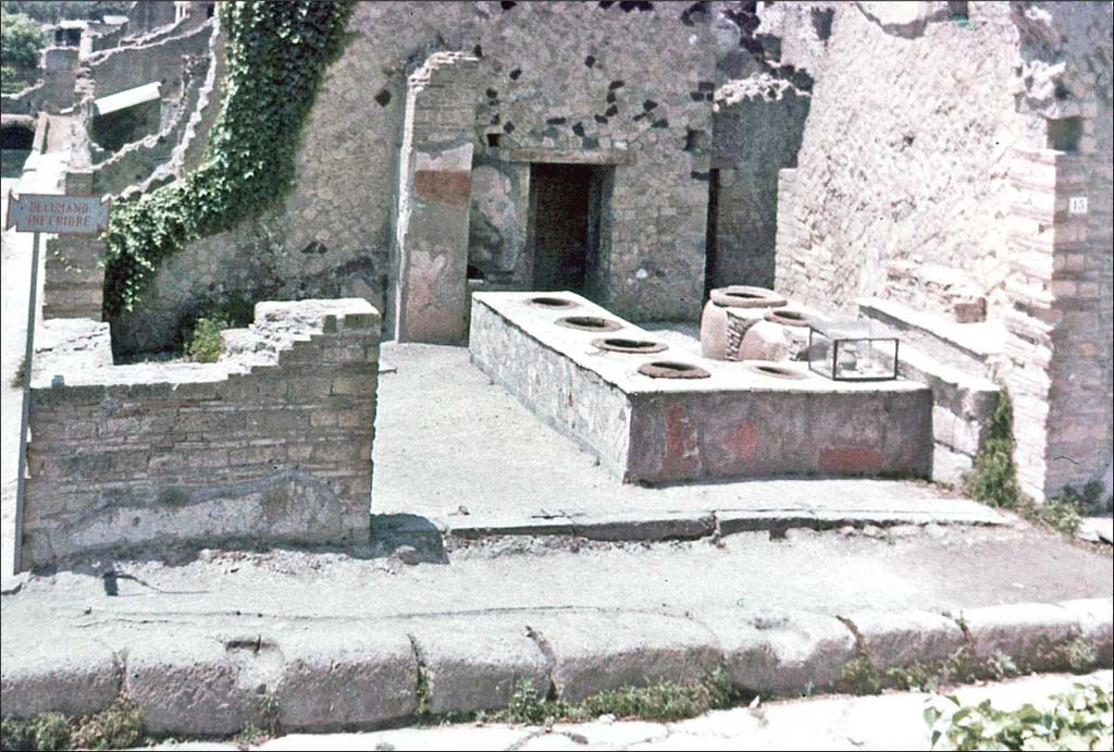IV.15 Herculaneum, June 1962. Looking south towards entrance doorway on Decumanus Inferiore.
Photo by Brian Philp: Pictorial Colour Slides, forwarded by Peter Woods
(H42.4 Herculaneum Thermopolium at crossroads).